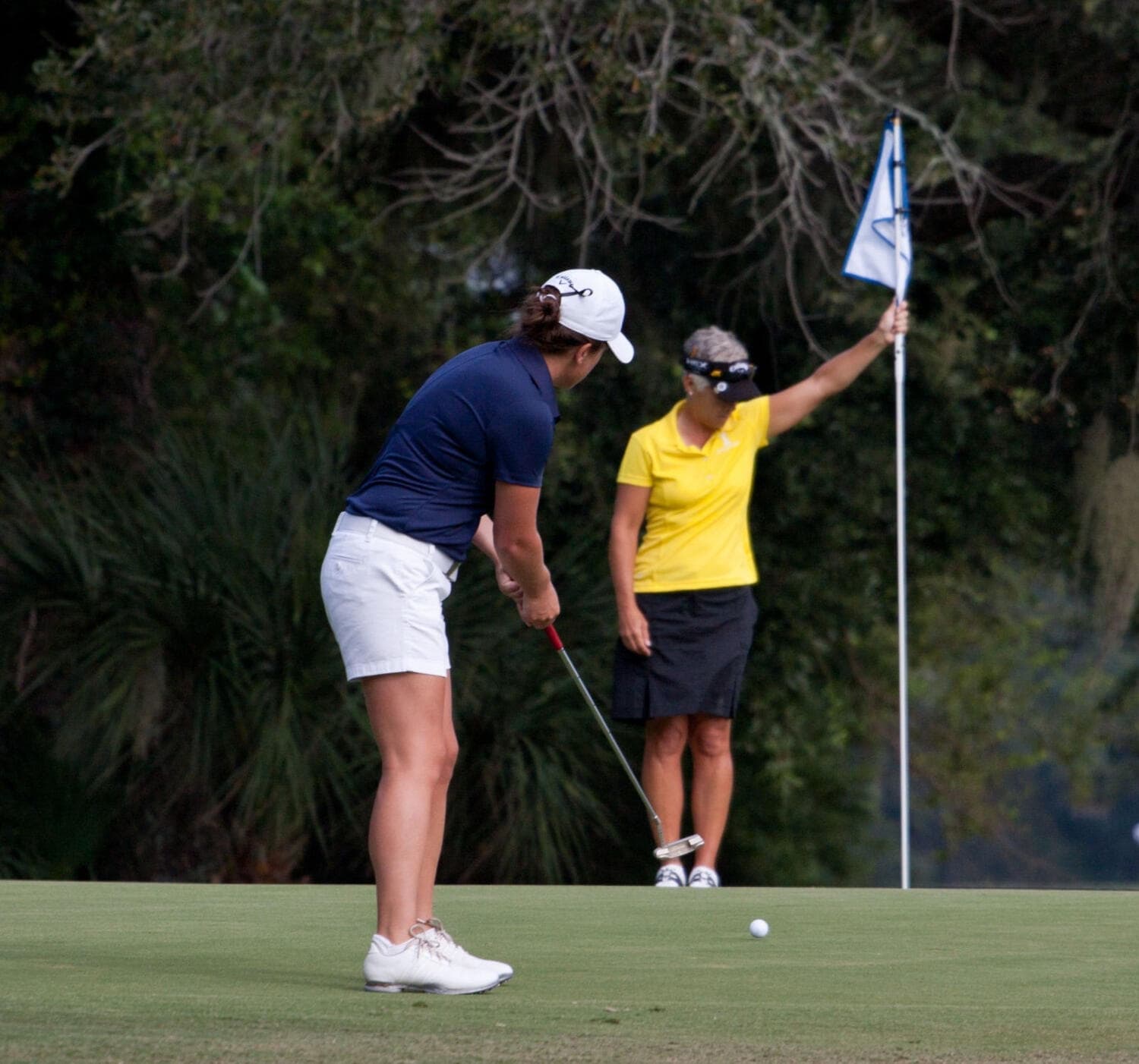 Golfers putting on the green together